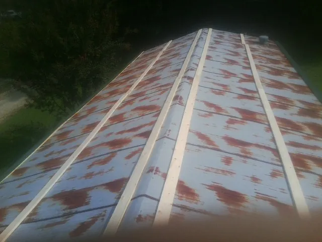 Rusted metal roof panels with new wood purlins before replacement — Storm Damage Roof Repair in Bluefield by Roofing Brothers