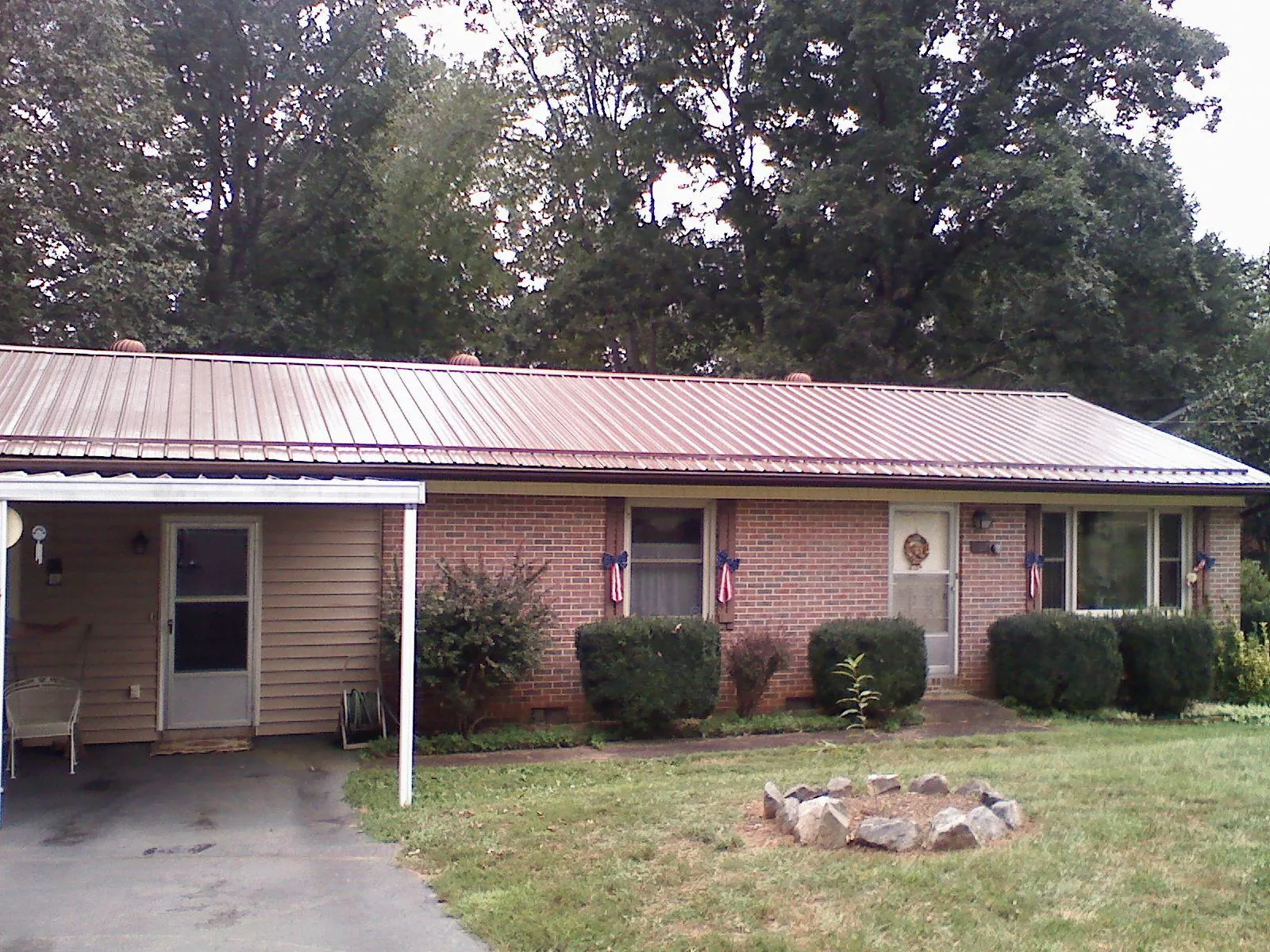 Bronze metal roof and carport on a brick ranch home — Roof Repair work by our crew in Bluefield