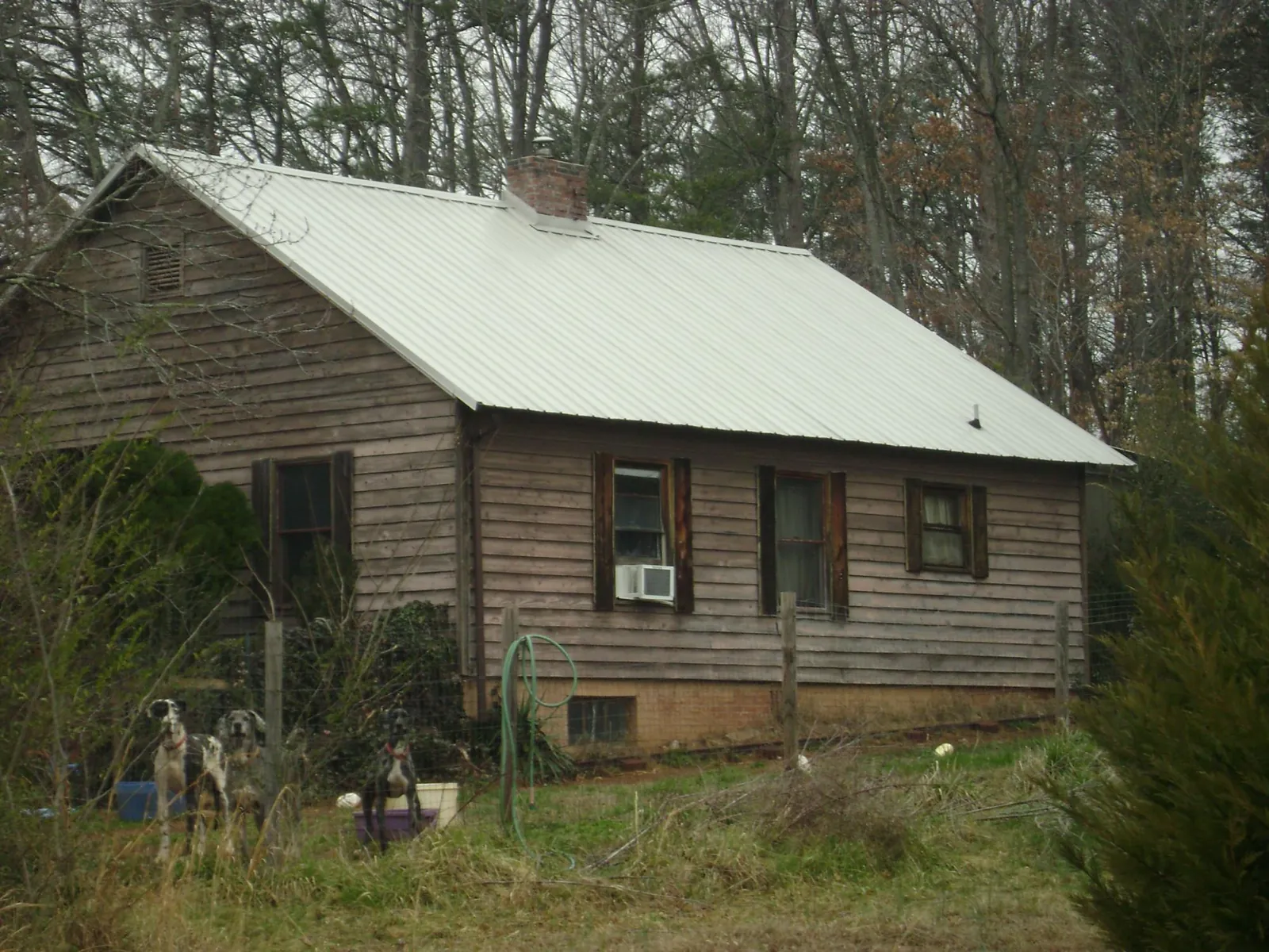 White metal roof on an old wood sided farmhouse, from a Metal Roof Installation job in Bluefield